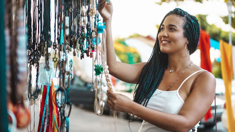 Woman looking at necklaces on market stall